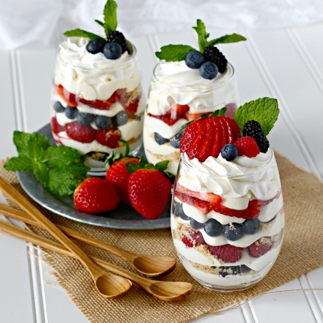 Individual berry cheesecake trifles with strawberries, blueberries, raspberries, blackberries, and no-bake cheesecake pudding mousse.