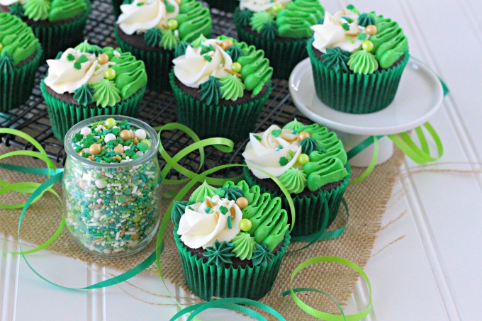 Irish Cream chocolate cupcakes topped with white and green buttercream piping and shamrock sprinkle mix