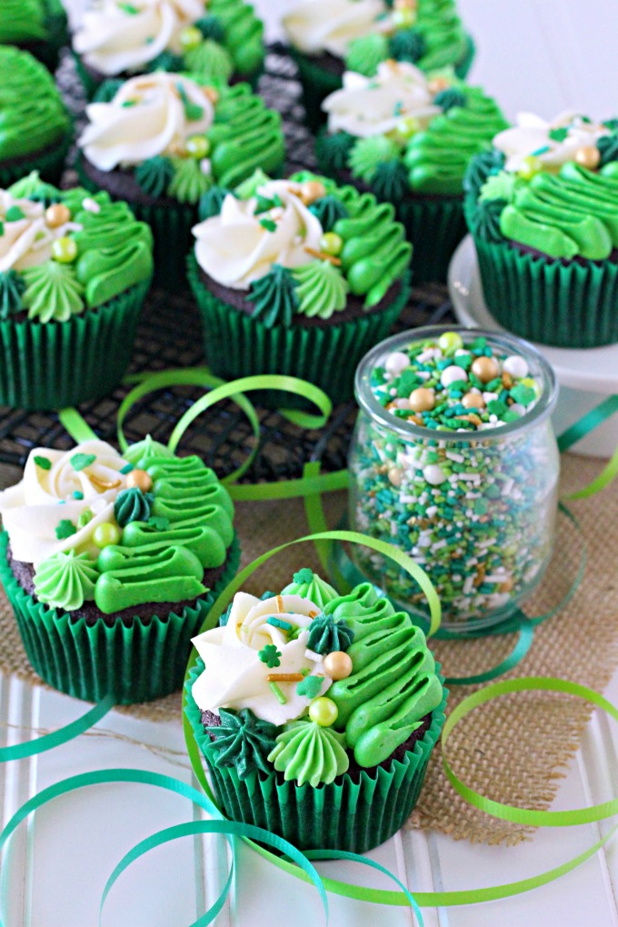 Irish Cream chocolate cupcakes topped with white and green buttercream piping and shamrock sprinkle mix