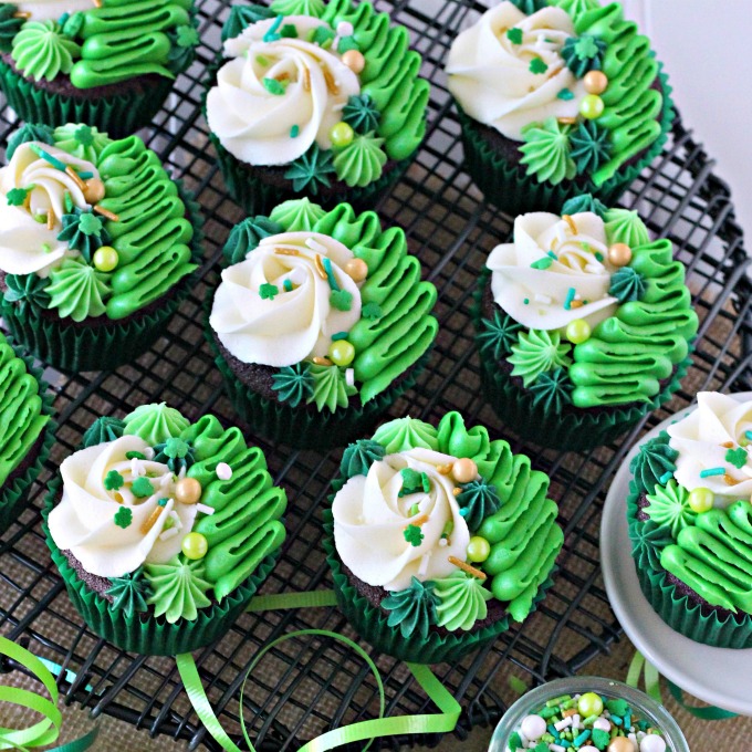 Irish Cream chocolate cupcakes topped with white and green buttercream piping and shamrock sprinkle mix