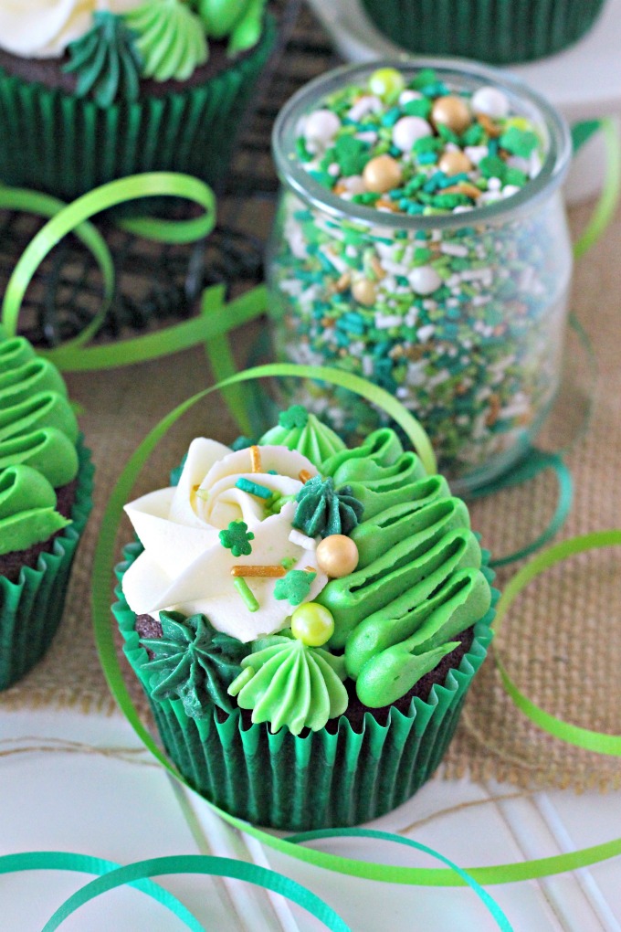 Irish Cream chocolate cupcakes topped with white and green buttercream piping and shamrock sprinkle mix