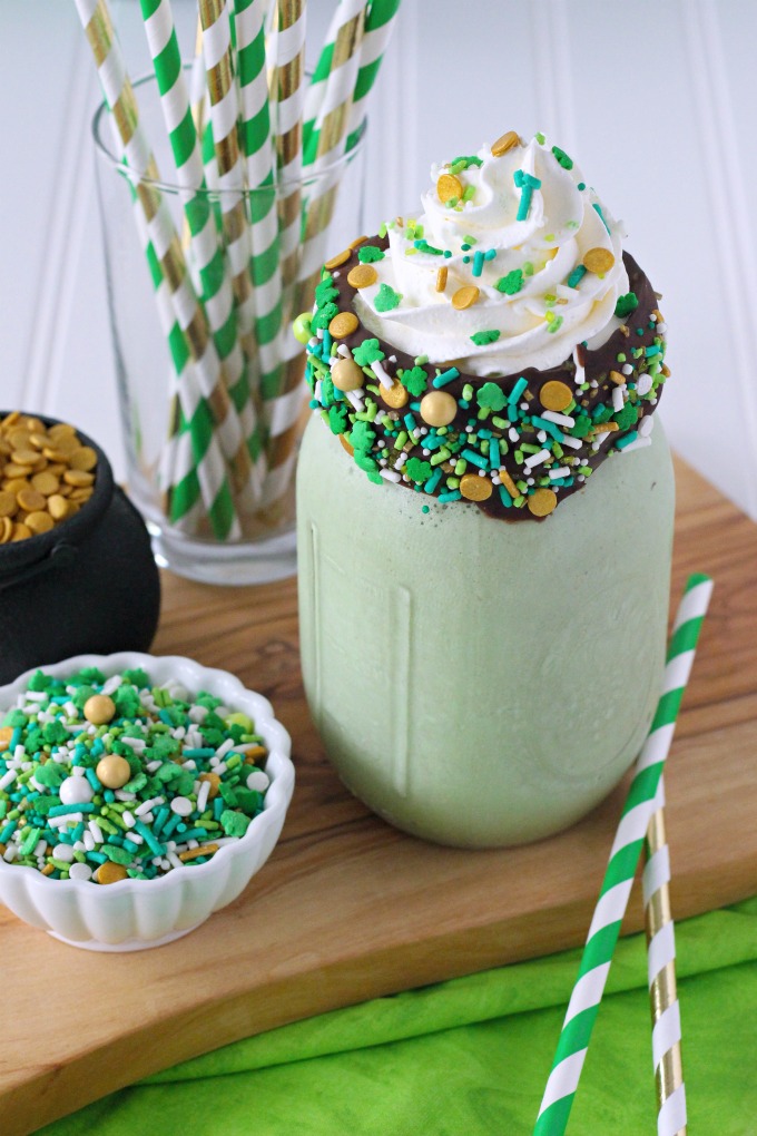 Green mint chocolate chip milkshake with chocolate coated sprinkle rim and whipped cream