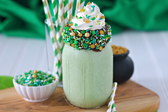 Green mint chocolate chip milkshake with chocolate coated sprinkle rim and whipped cream