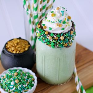 Green mint chocolate chip milkshake with chocolate coated sprinkle rim and whipped cream