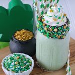 Green mint chocolate chip milkshake with chocolate coated sprinkle rim and whipped cream