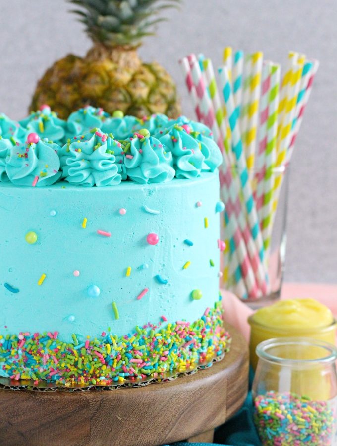 PIneapple cake with pineapple curd, teal frosting and tropical sprinkle mix