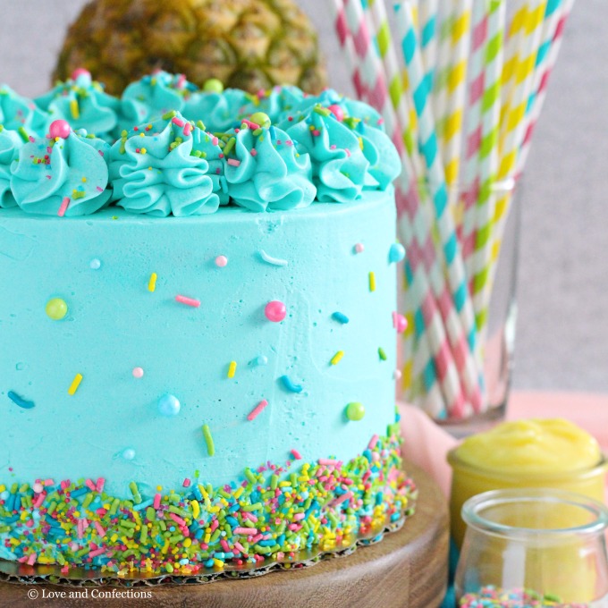 PIneapple cake with pineapple curd, teal frosting and tropical sprinkle mix