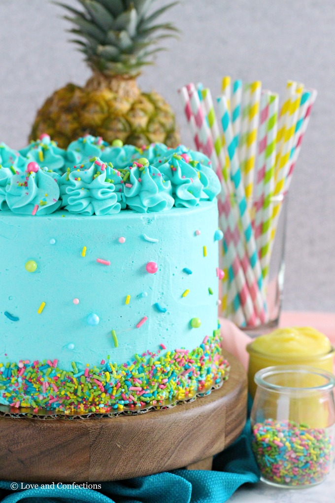 PIneapple cake with pineapple curd, teal frosting and tropical sprinkle mix