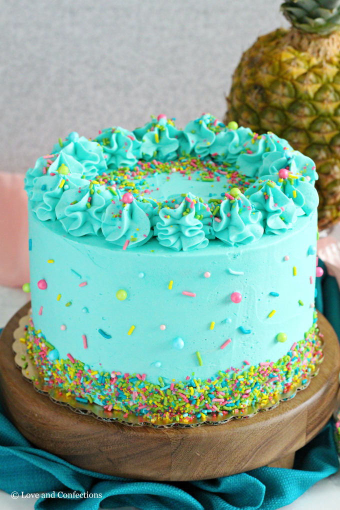 PIneapple cake with pineapple curd, teal frosting and tropical sprinkle mix