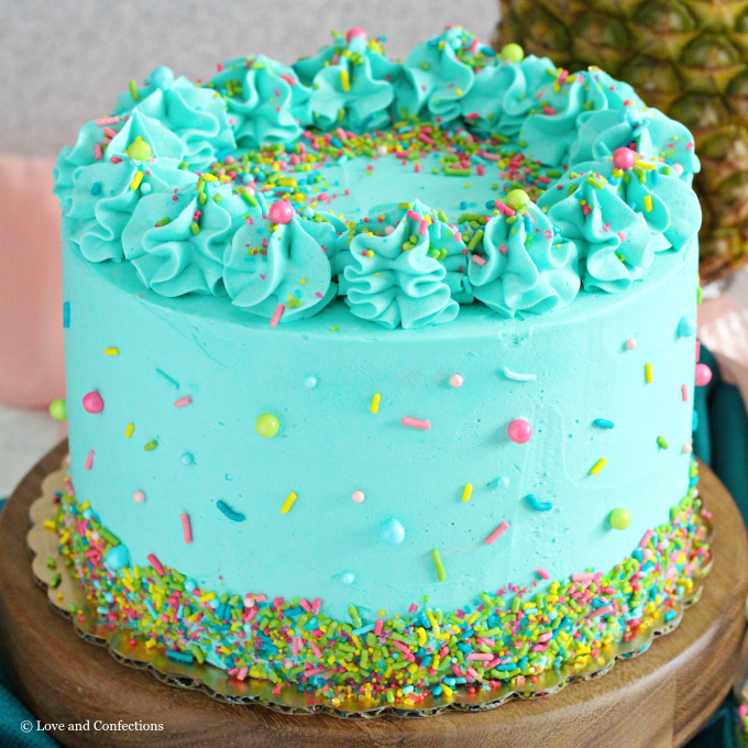 PIneapple cake with pineapple curd, teal frosting and tropical sprinkle mix