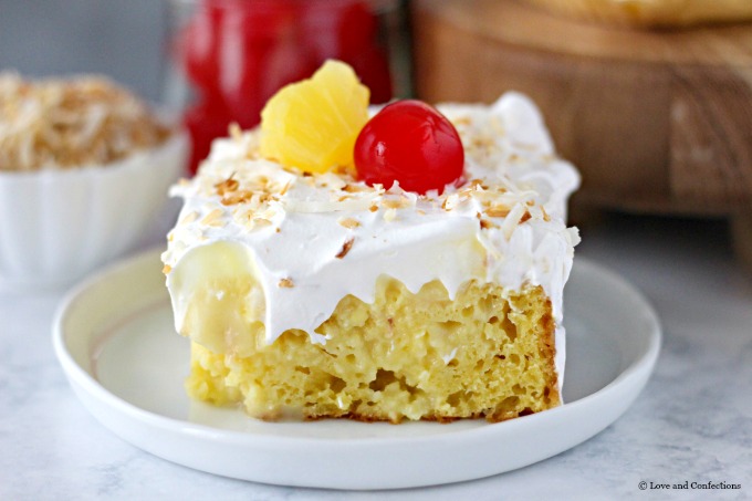 Easy Piña Colada Poke Cake - pineapple cake, coconut cream pudding, whipped topping, pineapple chunks and maraschino cherries