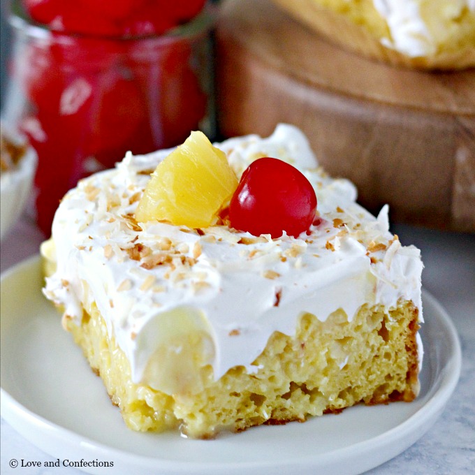 Easy Piña Colada Poke Cake - pineapple cake, coconut cream pudding, whipped topping, pineapple chunks and maraschino cherries