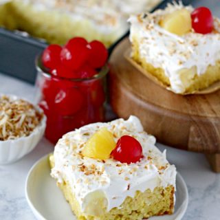 Easy Piña Colada Poke Cake - pineapple cake, coconut cream pudding, whipped topping, pineapple chunks and maraschino cherries