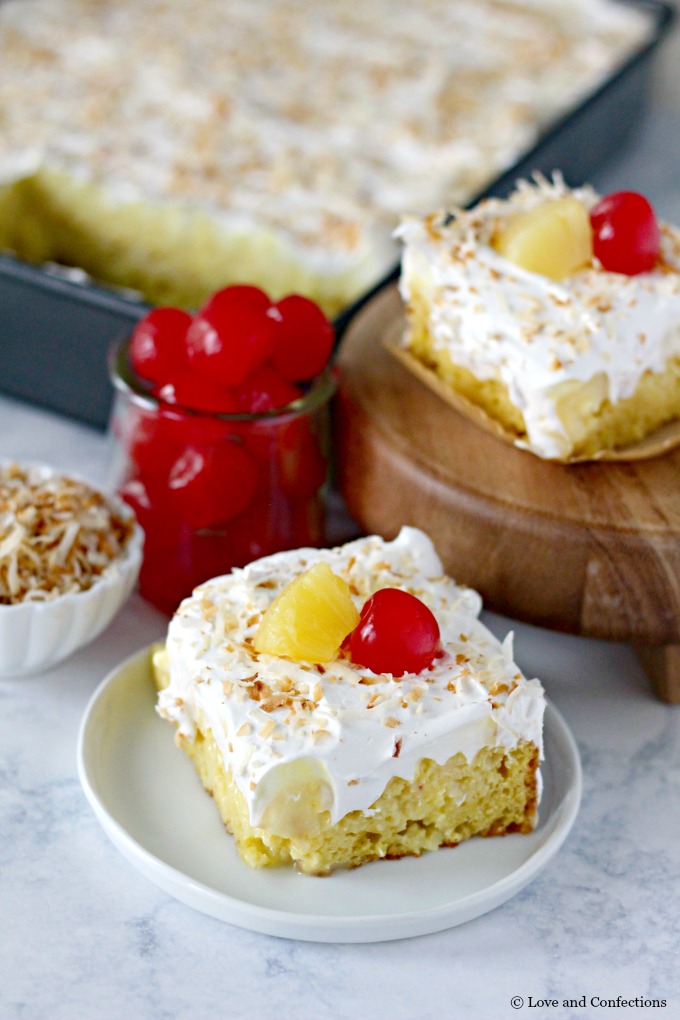 Easy Piña Colada Poke Cake - pineapple cake, coconut cream pudding, whipped topping, pineapple chunks and maraschino cherries